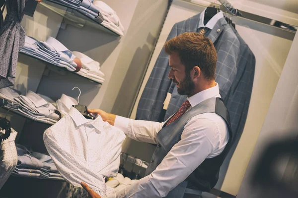 Jeune homme choisissant une boutique de chemises — Photo