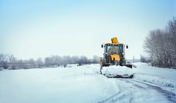 Śnieg. Ciągnik oczyszcza drogę po obfitych opadach śniegu. — Zdjęcie stockowe