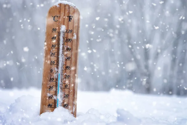 Termometr drewniany stojący w śniegu na zewnątrz na zimny dzień — Zdjęcie stockowe
