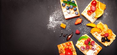 Yaban mersinli waffle, çilek ve pudra şekerli.