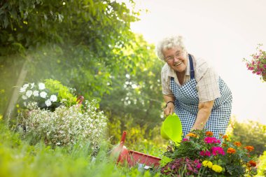 Happy woman take care of her flowers