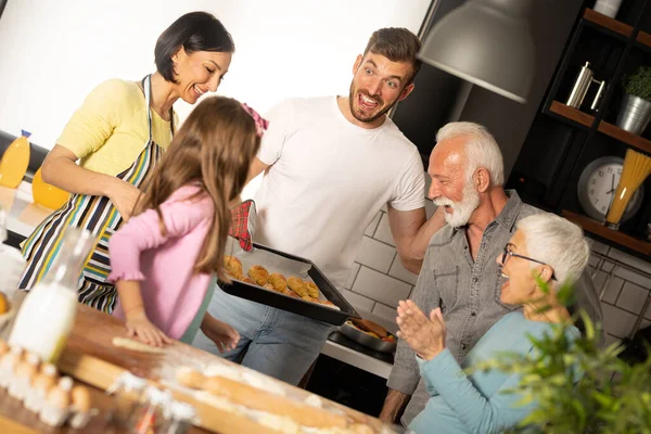 台所でおいしいロールを見て幸せな家族家族は一緒にパン屋を準備しています — ストック写真