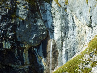 Ratikon sınır dağ kütlesi veya Ratikon Grenzmassiv, Mainfeld - Grisonlar Kantonu (Graubunden veya Graubuenden), İsviçre 'deki Falknisturm dağlarının altında mevsimlik güzel şelaleler