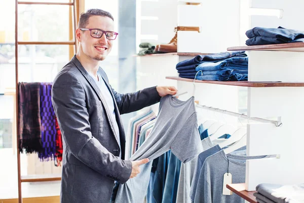 Homem escolhendo roupas no ashop — Fotografia de Stock