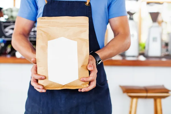 Homem segurando pacote de café em branco — Fotografia de Stock