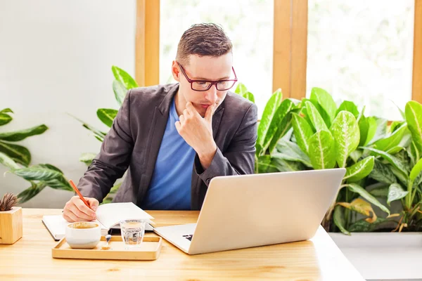 Man met laptop werken en denken — Stockfoto