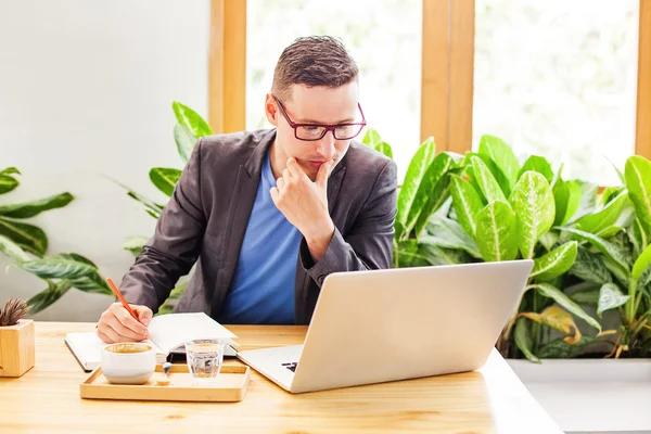 Man aan het werk op laptop aan balie — Stockfoto