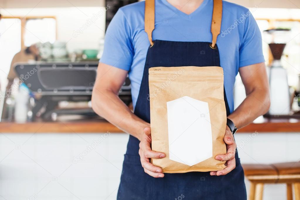 Man holding blank coffee package