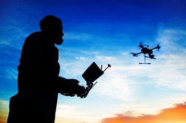 man outside with flying drone clipart