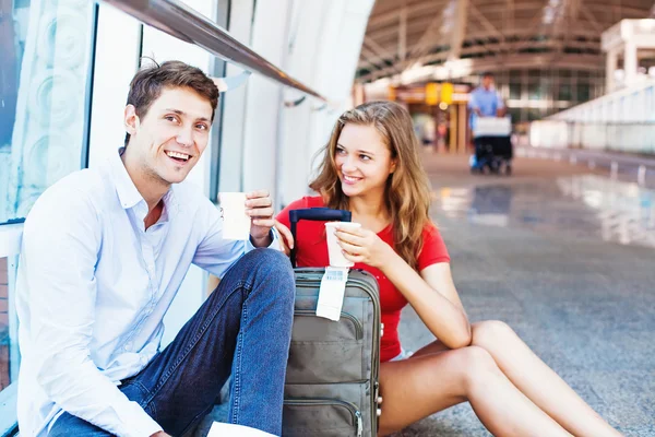 Man and woman in airport drinking coffee — Stock Photo, Image