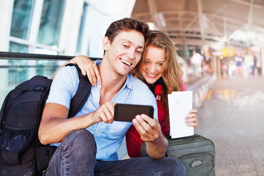 couple in airport with smart phone