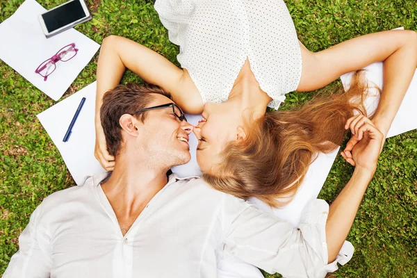 Man en vrouw met papieren en smartphone op gras — Stockfoto
