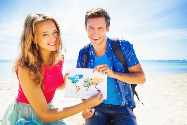 Paar bedrijf kaart op strand — Stockfoto