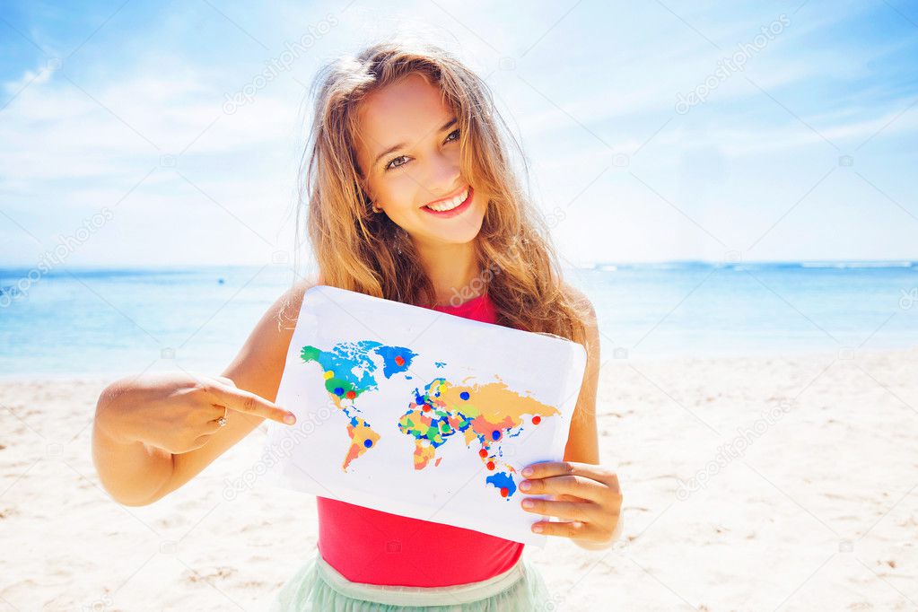 woman holding map on beach