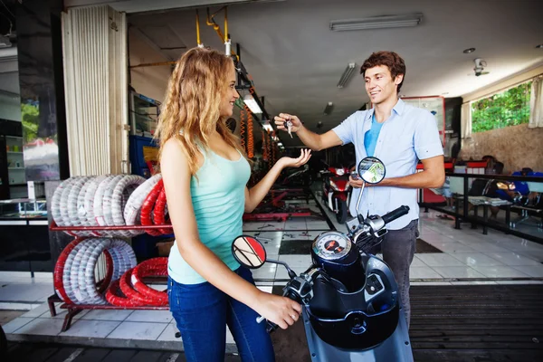 Mujer con scooter en taller de reparación — Foto de Stock