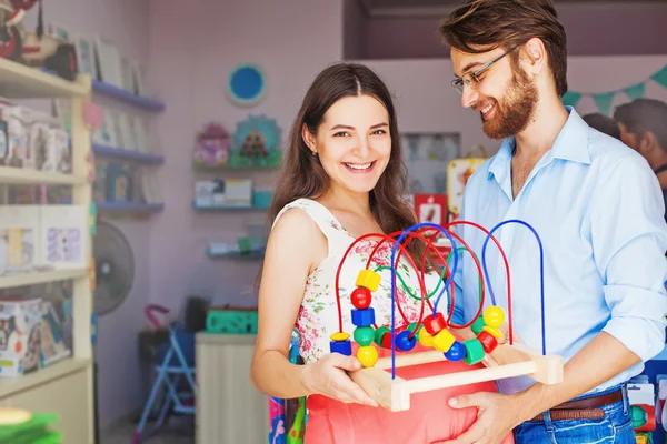 Nyblivna föräldrar att köpa baby leksak — Stockfoto
