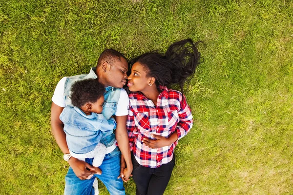 Африканская семья лежит на траве — стоковое фото