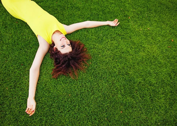 Kvinna liggande på en gräs — Stockfoto