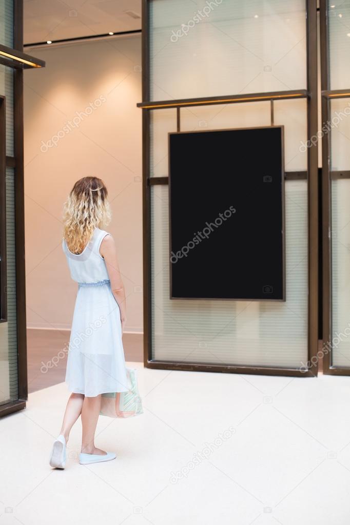 woman looking at blank poster  