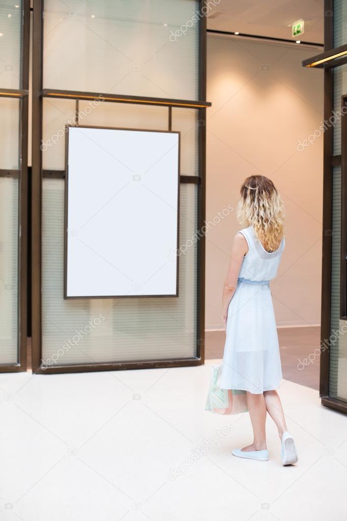 woman looking at blank poster  