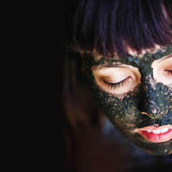 女作る黒い粘土マスク — ストック写真