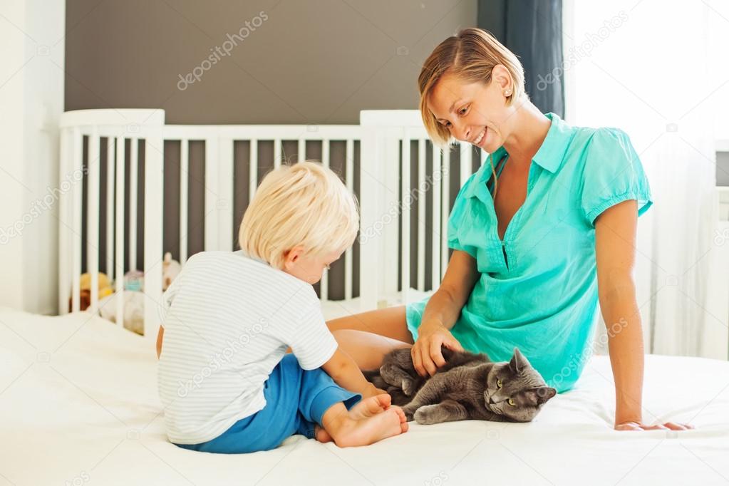 mother and son playing with cat