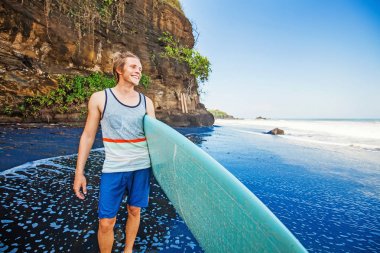 Adam sahilde surfboard ile