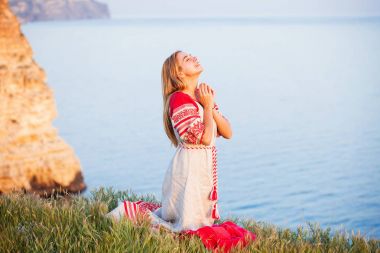 woman wearing traditional russian clothes passionately praying