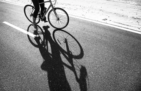 Woman riding bike on a road — Stock Photo, Image