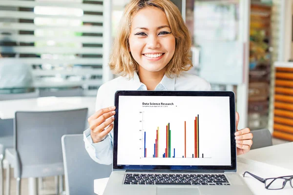 Mulher segurando um laptop mostrando gráficos — Fotografia de Stock