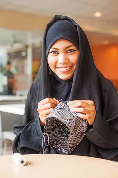 Mujer cosiendo una gorra de calavera — Foto de Stock