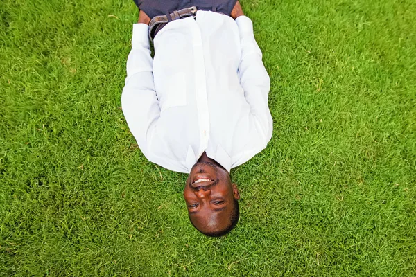 man lying down on a grass