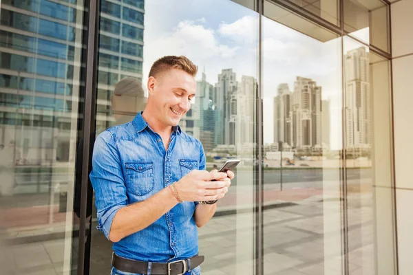 Man met smartphone in stad — Stockfoto