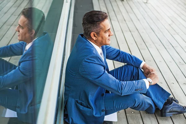 Ο άνθρωπος κάθεται φορώντας ένα μπλε κοστούμι συνεδρίαση — Φωτογραφία Αρχείου