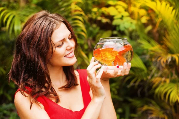 Женщина смотрит на золотую рыбу — стоковое фото