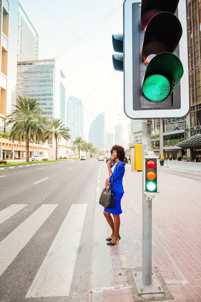 Beautiful African woman crossing the road on a street of Dubai