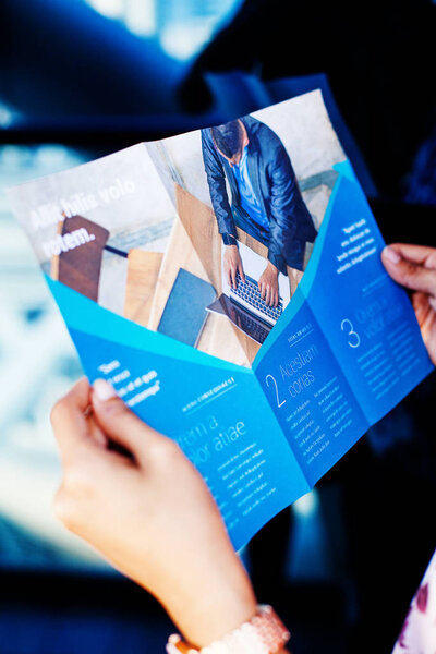 Hands holding a business brochure, close up
