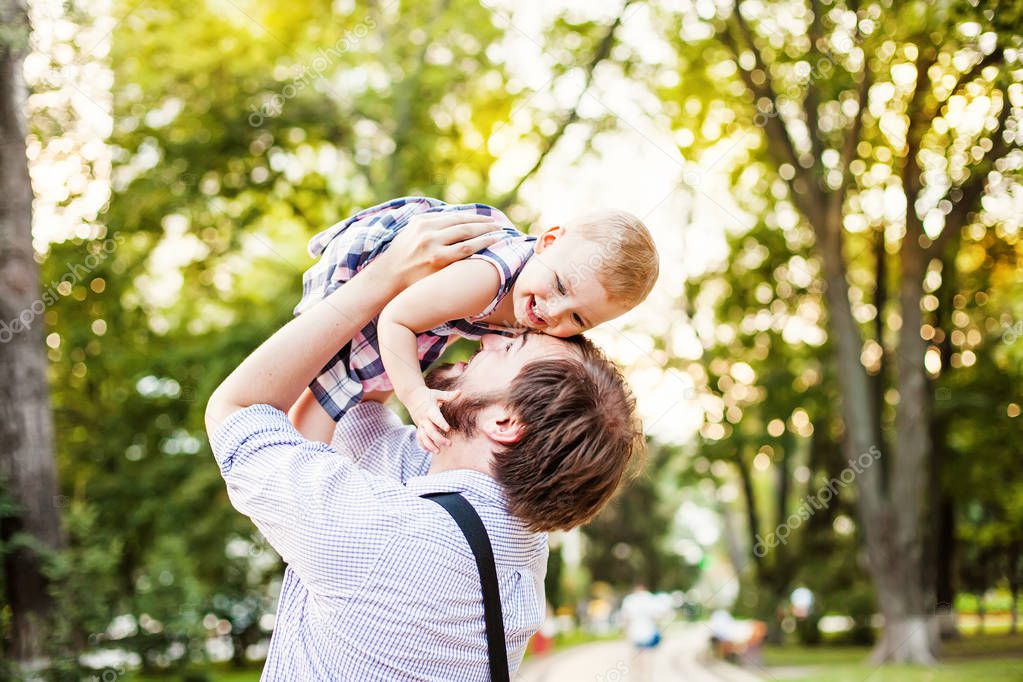 happy father holding girl outdoors 