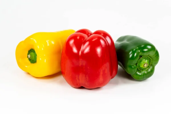Rote, grüne und gelbe Paprikafrüchte, die einen gesunden Lebensstil auf weißem Hintergrund darstellen — Stockfoto