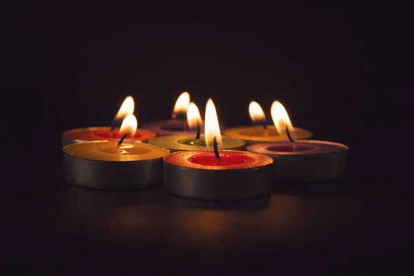 一群五彩缤纷的蜡烛在黑暗中燃烧 — 图库照片