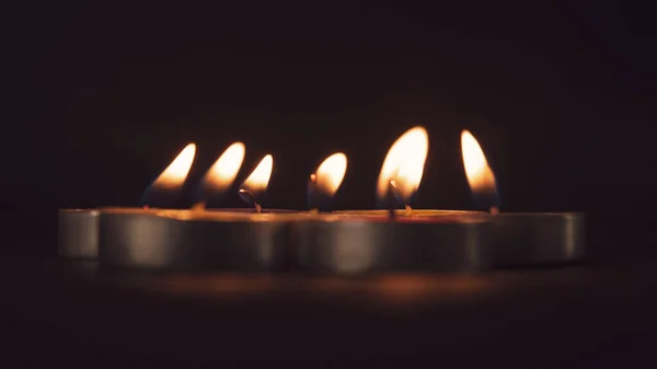 一群五彩缤纷的蜡烛在黑暗中燃烧 — 图库照片