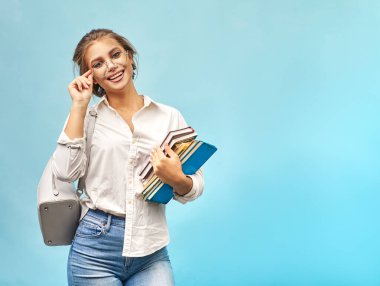 Gözlüklü sarışın kitapları elinde tutuyor.