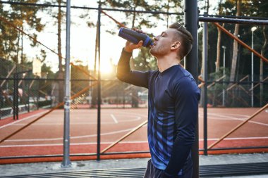 Adam eğitimden sonra su içiyor. 