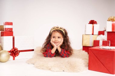 Küçük kız yeni yıl hediyeleriyle çevrili.