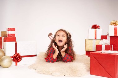 Küçük kız yeni yıl hediyeleriyle çevrili.