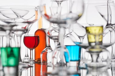 Beyaz arka planda renkli içecekler olan bardaklar.