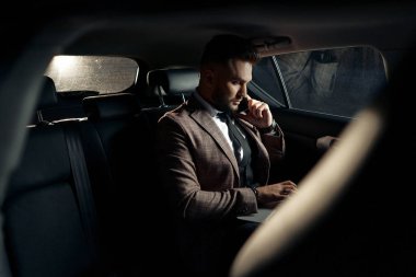 Dizüstü bilgisayarı ve telefonu olan bir adam.