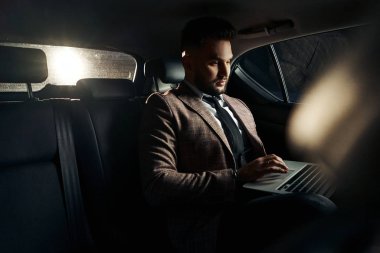 Dizüstü bilgisayarı ve telefonu olan bir adam.