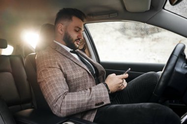 Dizüstü bilgisayarı ve telefonu olan bir adam.