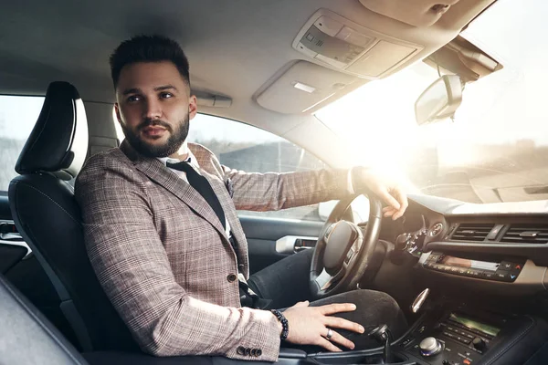 guy in car with laptop and phone